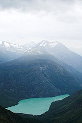 Photo property of Debra Austin. A green blue glacier fed lake nestles in a high mountain valley.