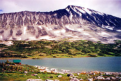 Photo courtesy of Mary Kirner. Planes line up next to a mountain cabin on a lake.